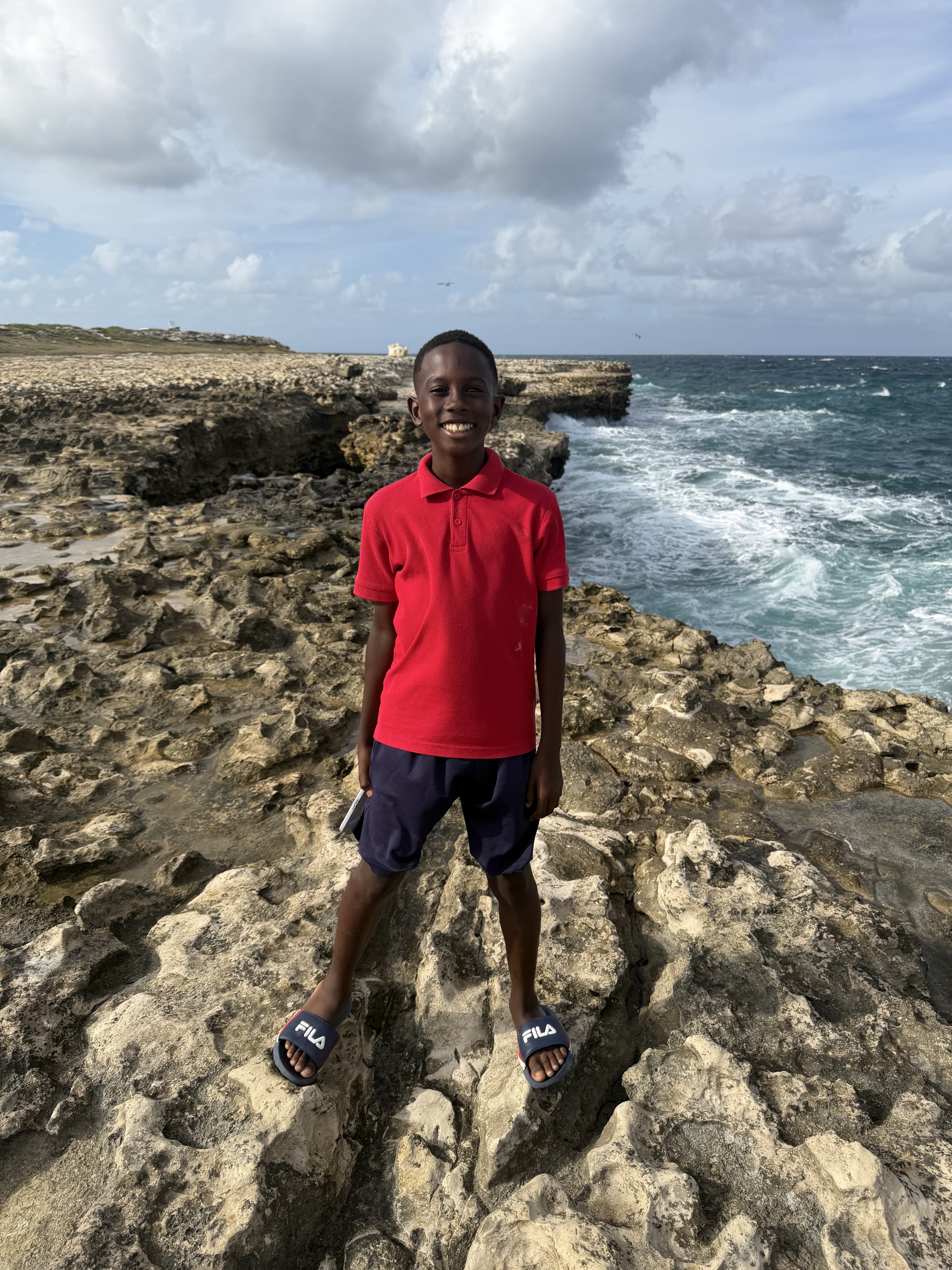 A young visitor standing at Devil’s Bridge in Antigua